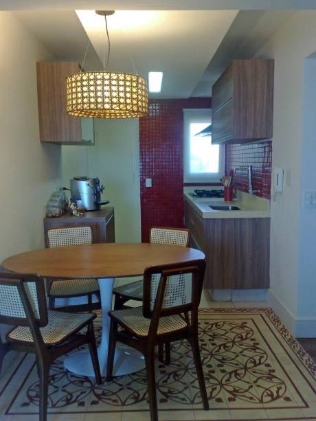 Na sala de jantar deste apartamento em São Paulo (SP), o piso de ladrilho hidráulico delimita a área do jantar, criando um charme especial em tons de areia e vermelho. O projeto é da designer de interiores Tekka Peric.