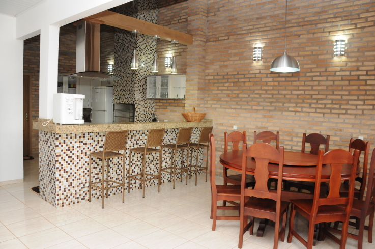 Neste apartamento, localizado em Campos de Júlio (MT), os tijolos maciços foram colocados com o intuito de realçar os demais materiais do espaço, como as pastilhas de vidro em tons de marrom na bancada. O espaço, de 3 x 8 m, foi projetado pelo arquiteto Wagner Giongo.