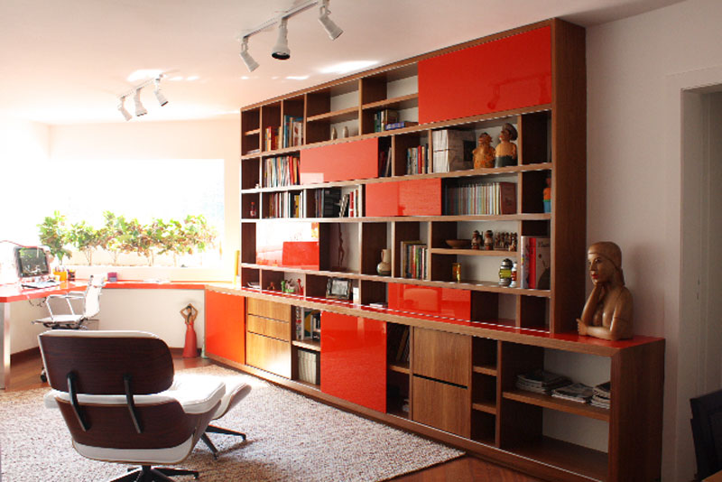 Neste home office, de 20 m², o grande destaque é a estante, desenhada pelo escritório responsável pelo projeto, o SP Estudio. Para organizar um espaço que servirá para armazenar livros e objetos, a escolha foi por móveis com espaços diversos, que proporcionam uma sensação de organização com movimento.