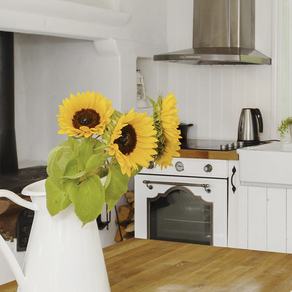 Significado das flores na decoração; girassóis em jarra branca em cozinha