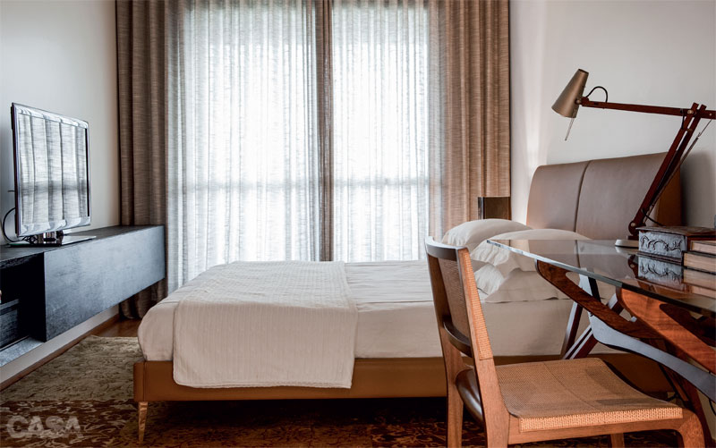 No quarto do casal, o aparador de freijó ebanizado (Top Móveis) apoia a TV e guarda revistas e documentos. Cama da italiana Maxalto e cadeira à venda na Micheliny Martins. Cortina de linho e enxoval da Guirlanda Confecções. Projeto Pedro Lázaro.