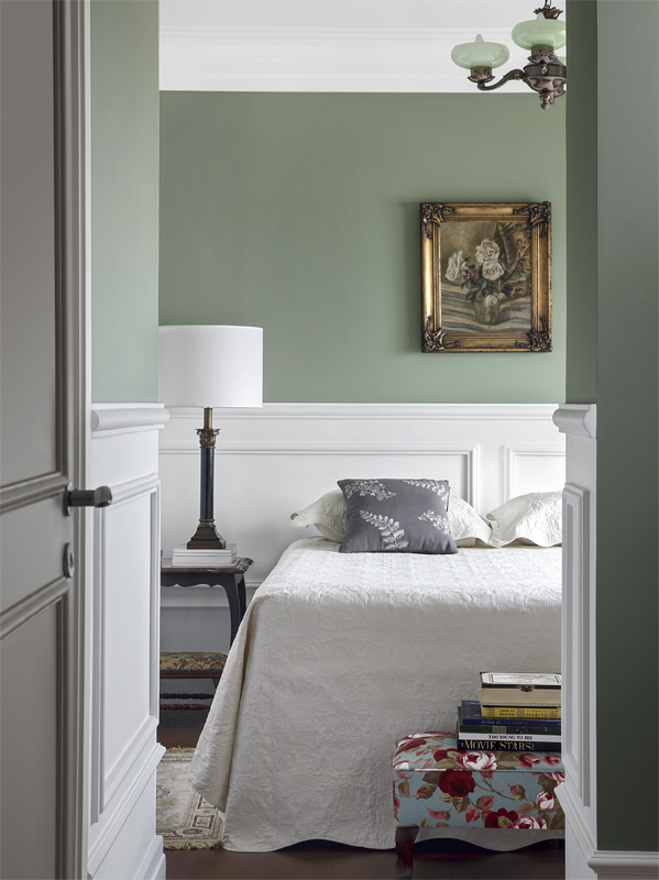 Peças douradas ganham destaque junto ao verde acolhedor. Sobre a cama, almofada com folhagens da Conceito Firma Casa. Nas paredes, Verde Pinheiro (Suvinil).