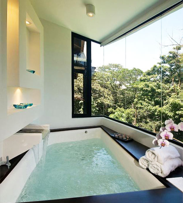 30-Para complementar a vista verde, o interior investiu em branco e preto, com banheira com cascata