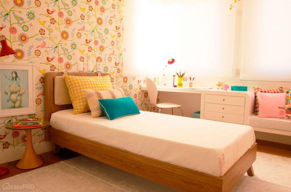 Quarto de menina com canto de estudos. Há de um lado uma escrivaninha acompanhada da cadeira Ant, de Arne Jacobsen, e do outro, um sofá para leituras. O gaveteiro faz a transição entre os dois setores. Por não ter altura fixa, o móvel pode ser ajustado a características biométricas da menina na medida em que ela for crescendo. Projeto de Sandro Clemes.