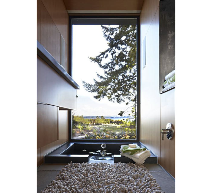 36-Um tapete felpudo recepciona o morador, acostumado a tomar banho admirando esta vista