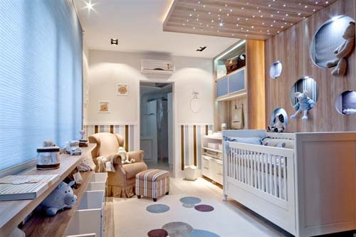 O quarto do bebê projetado pela arquiteta Daniele de Souza Cardoso é marcado pela predominância de tons claros. O closet, com nichos definidos para tudo, até mesmo para o carrinho, facilita a organização. O berço, com acabamento de palha branca, fica próximo ao tapete de náilon com círculos que acompanham o desenho do painel de madeira, cujos leds formam um céu estrelado. A poltrona com pufe proporciona conforto para a mãe na amamentação.