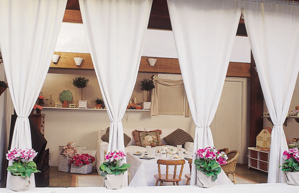Edícula com roupa de festa: cortina de linhão e vasos Bambu Flores Design.