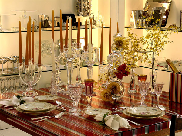 O tampo da mesa é espelhado com listras coloridas e porcelana Rosenthal.