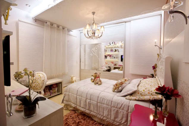 Este quarto, projetado pela arquiteta Adriana Lima para uma menina de sete anos, lembra o típico quarto de princesa. Não por acaso, a profissional optou por enfeitar o espelho que reveste o armário com um adesivo em formato de uma menininha com uma coroa, uma pequena princesa.