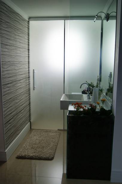 Neste lavabo, de uma casa em Atibaia (SP), as arquitetas Carla Teles e Marília Serra utilizaram o vidro em duas situações: o temperado de 6mm serve como uma pequena divisória e é ligado a um cachepô do mesmo material. Já a porta do lavabo é feita de vidro serigrafado de 6mm, que dá privacidade ao ambiente.