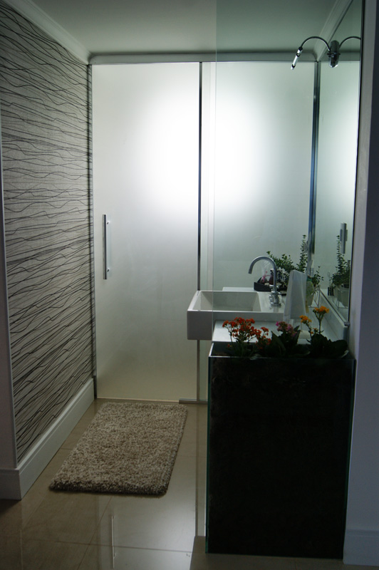 Neste lavabo, de uma casa em Atibaia (SP), as arquitetas Carla Teles e Marília Serra utilizaram o vidro em duas situações: o temperado de 6mm serve como uma pequena divisória e é ligado a um cachepô do mesmo material. Já a porta do lavabo é feita de vidro serigrafado de 6mm, que dá privacidade ao ambiente. Neste lavabo, de uma casa em Atibaia (SP), as arquitetas Carla Teles e Marília Serra utilizaram o vidro em duas situações: o temperado de 6mm serve como uma pequena divisória e é ligado a um cachepô do mesmo material. Já a porta do lavabo é feita de vidro serigrafado de 6mm, que dá privacidade ao ambiente.