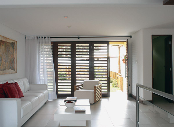 No living, uma antiga porta de 80 cm deu lugar a uma esquadria formada por tr...