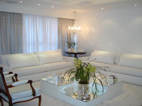 Feita para um casal de meia-idade, a sala tem design clássico, notado nas mesas laterais, nas poltronas e nos lustres. O ambiente, assinado pela decoradora Claudia Mattos, também contempla toques contemporâneos, como a mesa espelhada – pedido da dona da casa, que adora espelhos.