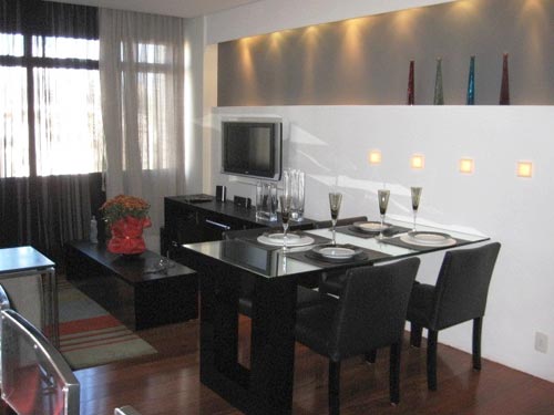 A decoradora Luciane Leal, de Belo Horizonte (MG), projetou o living para um rapaz solteiro na faixa dos 30 anos. Cores sóbrias predominam no espaço, onde a madeira ebanizada predomina. Uma das paredes é coberta por painel de laca branca, onde pequenas luminárias são embutidas.