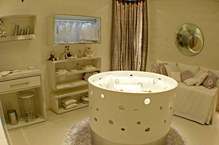 A peça mais interessante do Quarto do Bebê, das designer de interiores Adriana Mantovani, Valéria Repa e Márcia Duarte é o berço redondo, projetado por elas e executado pela Marcenaria Moderna. O espaço ainda conta com um espelho com foto do bebe da Color Vidros, cama Box da A Colchoaria, piso de porcenalato branco, da Portofino, além de cortinas, tapete, roupas de cama e papel de parede do Ateliê Viviane Catelan.