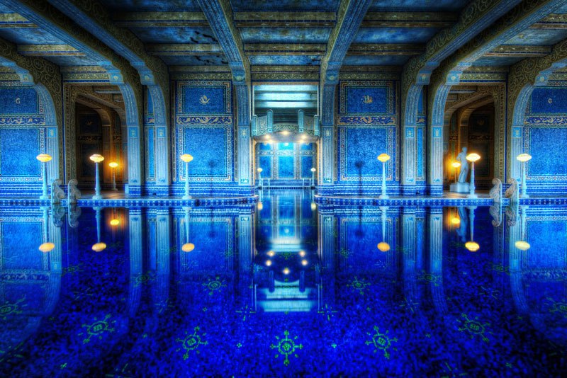 No meio das colinas da Califórnia, o <a href="https://hearstcastle.org/">Hotel Hearst Castle</a> lugar é uma mistura de vários tipos de influências arquitetônicas. A piscina interna, conhecida como Romana, tem o seu entorno totalmente decorado com murais que fazem referência à cidade italiana e as casas de banho termais.