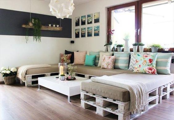 Você pode montar um sofá no formato que desejar com paletes e almofadas.