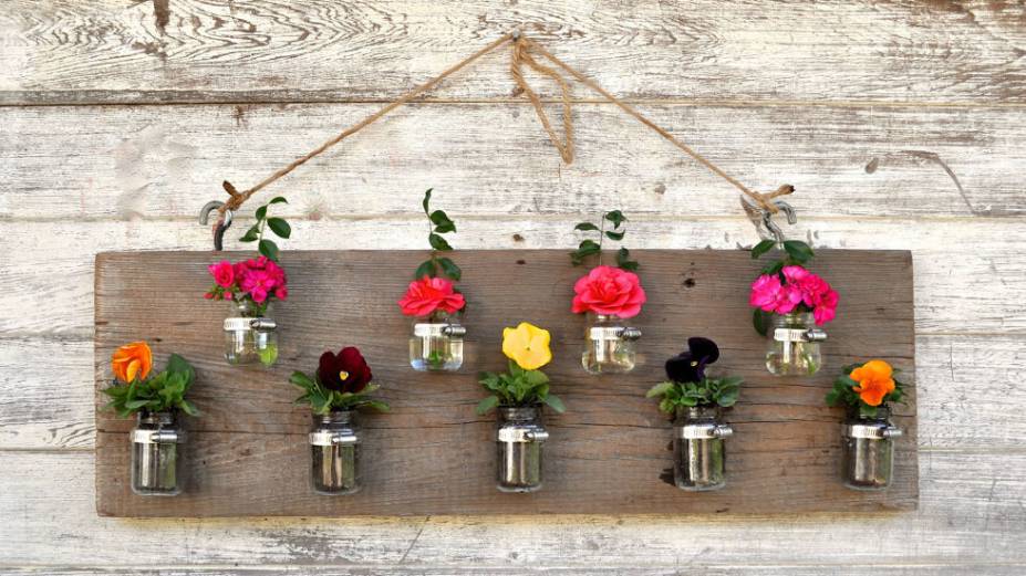 Com potes de vidro. Aprenda o passo a passo (em inglês) <a href="https://www.makelifelovely.com/2013/02/upcycled-baby-food-jars-wood-vase.html">aqui</a>.