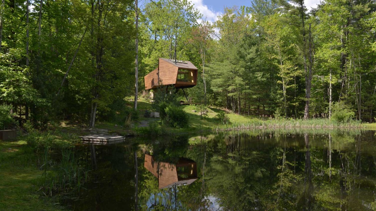 casa de madeira com um lago em uma floresta