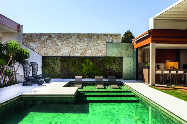 No projeto dos arquitetos Gil Cioni e Olegário de Sá, a escolha foi pelo jardim vertical aliado a piscina com revestimento da pedra verde hijauem.