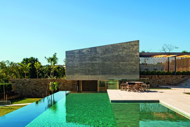 Piscina com beirada infinita em casa com projeto dos arquitetos Henrique Reinach e Maurício Mendonça e paisagismo de Raul Pereira Arquitetos Associados.