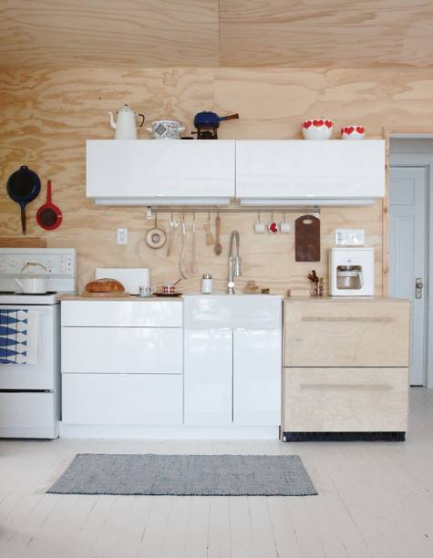 Donos de uma loja de design em Toronto, o casal de moradores escolheu o estilo minimalista para a cozinha de seu chalé. O refrigerador pequeno, que parece ser de madeira, tem apenas duas gavetas e se esconde ao lado do balcão branco. Por todo o ambiente, panelas e utensílios foram pendurados nas paredes para facilitar o acesso.