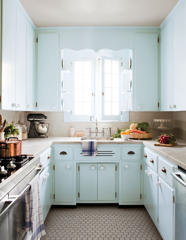 Gabinetes vibrantes e coloridos abrilhantam esta cozinha pequena. O azul pastel e o piso hexagonal são tanto estilosos quanto charmosos, trazendo uma aparência retrô ao espaço.