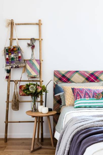 Além da roupa de cama, as estampas também aparecem nos acessórios da moradora, pendurados em uma escada rústica.