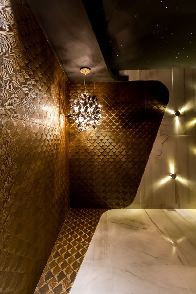 <strong>Baño: Destellos Cálidos</strong> - Rosario Abularach. Neste banheiro, o revestimento texturizado e dourado – que faz referência ao Oriente Médio – desce das paredes e cobre parte do chão.