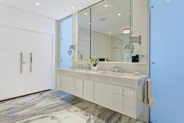 O mármore italiano Calacata imprimiu sofisticação à sala de banho do casal, que foi ambientada com armários brancos e uma generosa banheira com vista para o quarto.