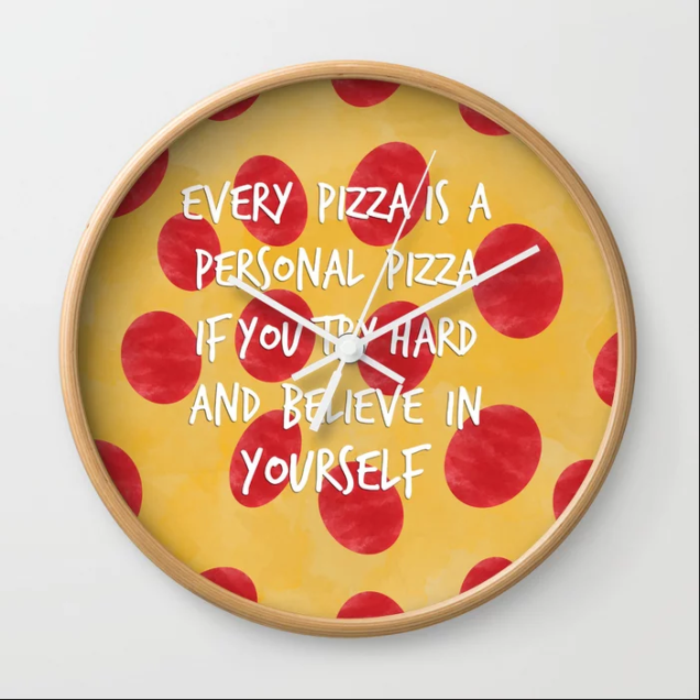 Um divertido relógio com uma mensagem de incentivo: toda pizza é uma pizza individual se você se esforçar e acreditar em si mesmo. Disponível para compra na <a href="https://society6.com/product/inspirational-pizza_wall-clock#33=282&34=285">Society 6</a>.