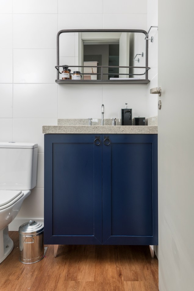 No banheiro, o ponto de cor do espaço está no armário da bancada. O azul do móvel funcionou como um contraste perfeito no ambiente todo branco.