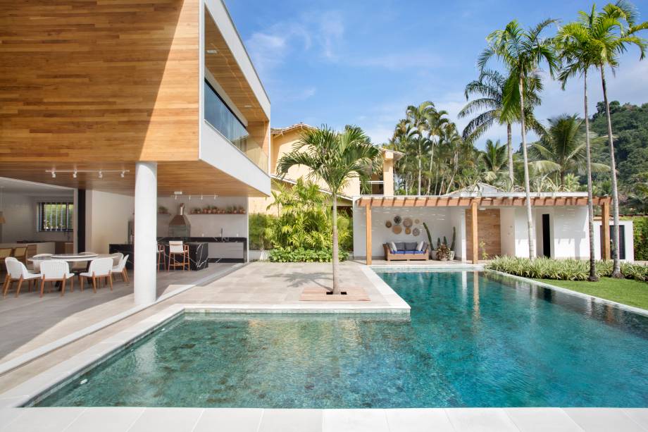 Um dos destaques da residência, a piscina em forma de L, às margens do canal, é revestida em pedra Hijau, material natural de origem vulcânica originário da Indonésia que apresenta diversos tons de verde intensificados em contato com a água, de acordo com a incidência de luz solar. Um dos destaques da residência, a piscina em forma de L, às margens do canal, é revestida em pedra Hijau, material natural de origem vulcânica originário da Indonésia que apresenta diversos tons de verde intensificados em contato com a água, de acordo com a incidência de luz solar.