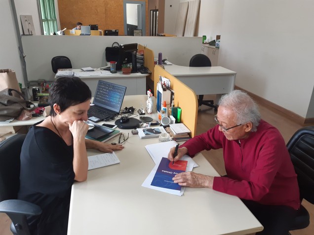 Ruy Ohtake autografa o livro-folder com um resumo de sua obra para Lívia Pedreira, diretora superintendente de CASA.COM.BR.