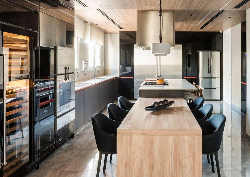 A reforma deste apartamento foi comandada pelo escritório Ponto Arq. Na cozinha, o forro revestido em madeira aquece o ambiente, já o piso em porcelanato oferece alta resistência