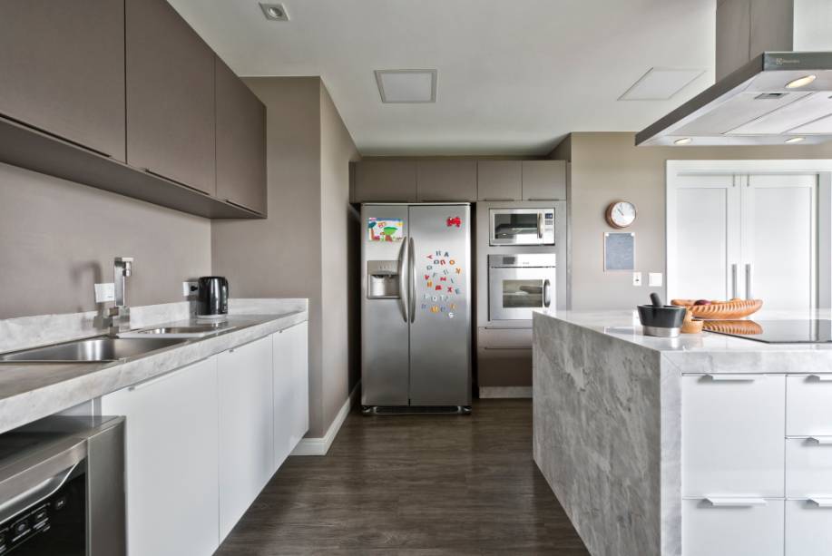 Nesta cozinha gourmet, projetada pela arquiteta Claudia Pereira, paleta de cores escolhida é neutra e os revestimentos usados dão um toque de sofisticação ao décor. A ilha central serve como apoio na hora de preparar as refeições, mas também funciona como um balcão