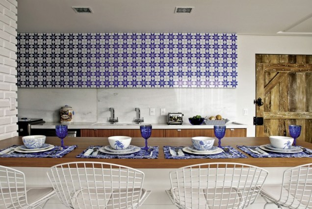Painel que imita azulejos, armários embutidos e banquetas altas compõem a cozinha deste apartamento, projetado pela arquiteta Andréa Murao, em parceria com a arquiteta Milena Aguiar