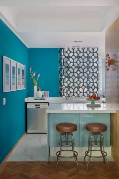 Projetada pela arquiteta Paloma Yamagata, essa mini cozinha americana não é nada básica. Os tons de azul e a divisória de cobogós são os grandes destaques da ambientação