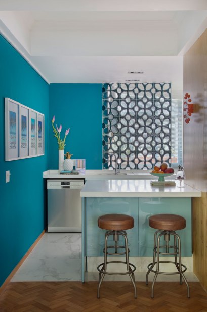 Projetada pela arquiteta Paloma Yamagata, essa mini cozinha americana não é nada básica. Os tons de azul e a divisória de cobogós são os grandes destaques da ambientação