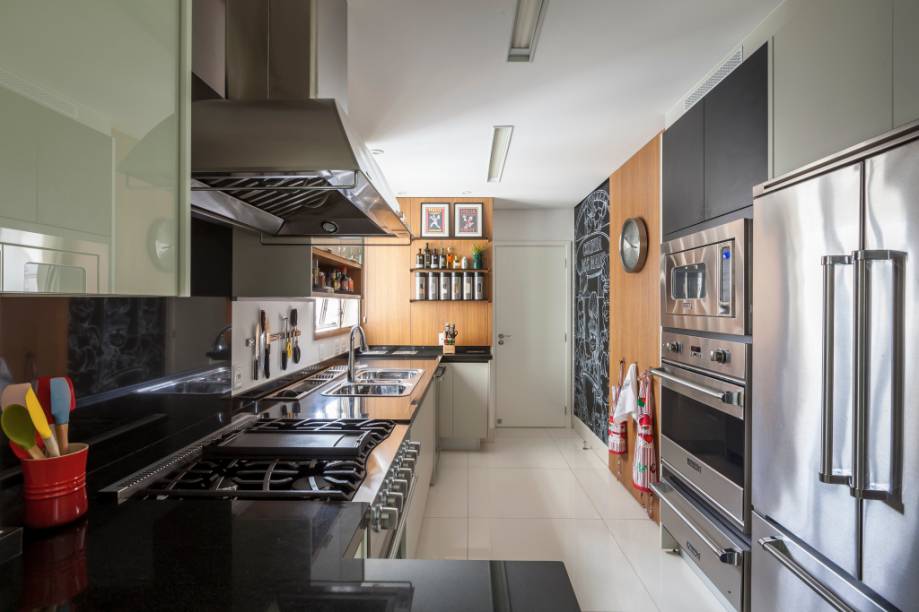 A arquiteta Luciana Tomas comandou a reforma deste apartamento. Na cozinha, a profissional apostou na combinação de eletrodomésticos em aço inox com o cinza da marcenaria planejada e o preto da pedra de granito