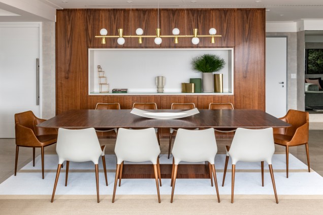 Para a sala de jantar, um dos pedidos dos clientes era um móvel com função de cristaleira. A arquiteta pensou, então, em fazer uma releitura de uma cristaleira moderna com armários em marcenaria para guardar as taças, pratos e talheres e um nicho que serve como um apoio durante um almoço em família, como por exemplo, para apoiar <em>réchauds</em>. Para a sala de jantar, um dos pedidos dos clientes era um móvel com função de cristaleira. A arquiteta pensou, então, em fazer uma releitura de uma cristaleira moderna com armários em marcenaria para guardar as taças, pratos e talheres e um nicho que serve como um apoio durante um almoço em família, como por exemplo, para apoiar <em>réchauds</em>.
