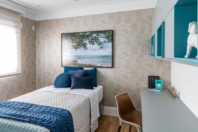 Uma das suítes do apartamento foi direcionada aos hospedes do casal: um quarto aconchegante e despojado, com tons de azul e cinza. O papel de parede usado lembra cimento queimado e o quadro com paisagem de praia (Gigi Monteiro) traz tranquilidade ao ambiente. Uma das suítes do apartamento foi direcionada aos hospedes do casal: um quarto aconchegante e despojado, com tons de azul e cinza. O papel de parede usado lembra cimento queimado e o quadro com paisagem de praia (Gigi Monteiro) traz tranquilidade ao ambiente.