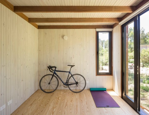 O espaço intermediário entre cada metade da casa também tem acesso a um terraço semi-fechado, que é coberto por uma treliça de madeira.