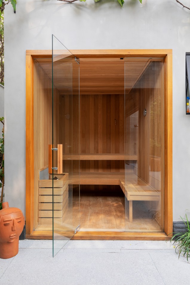 A sauna é inteira em vidro com revestimento em madeira Tauari.