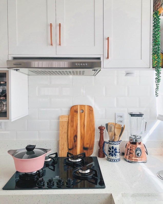 A cozinha do @casaape segue o estilo minimalista e escandinavo, com pontos de cor rosé nas maçanetas dos armários e utensílios de cozinha.