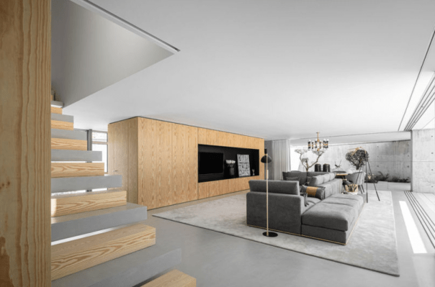A cor cinza do concreto ao ar livre continua no interior, com o piso, o mobiliário e as escadas alternadas na escada aberta. Os cinzas frios são complementados com detalhes de madeira natural usados por toda parte. A cor cinza do concreto ao ar livre continua no interior, com o piso, o mobiliário e as escadas alternadas na escada aberta. Os cinzas frios são complementados com detalhes de madeira natural usados por toda parte.