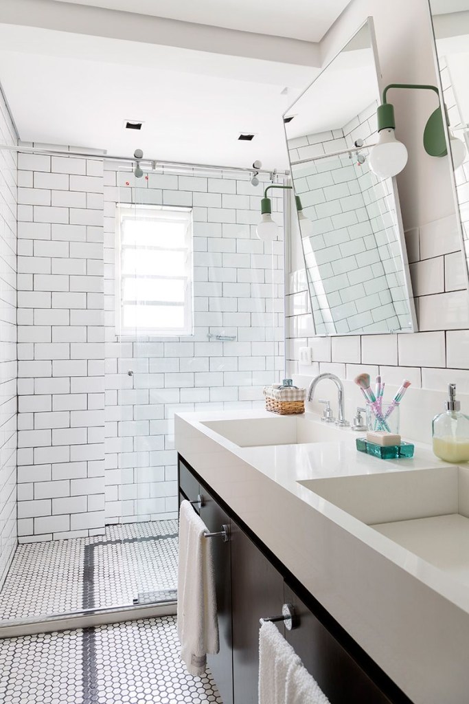 Banheiro branco revestido com subway tiles e espelho