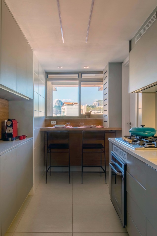 Na cozinha, a simplicidade do projeto reflete o estilo de vida da família, com direito a uma bancada sob a janela, de onde se pode apreciar ao longe o Pão-de-Açúcar durante o café da manhã e as refeições rápidas do dia a dia.