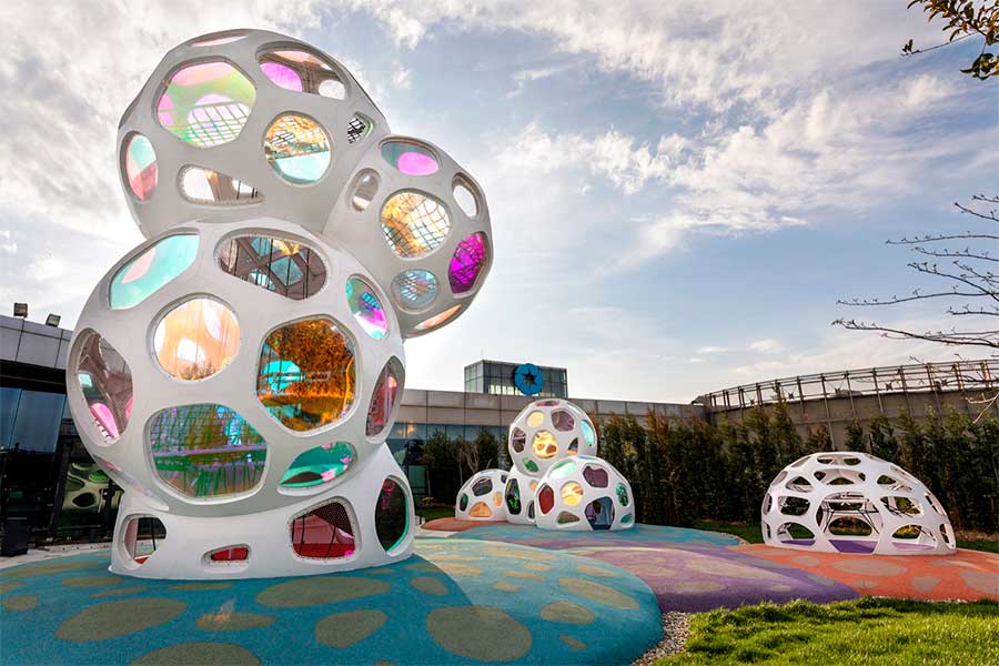 Nuvens de aço branco com janelas coloridas transformam playground