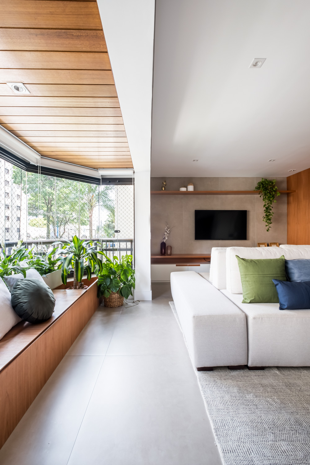 Banco faz as vezes de baú e de jardineira em apartamento de 140 m²